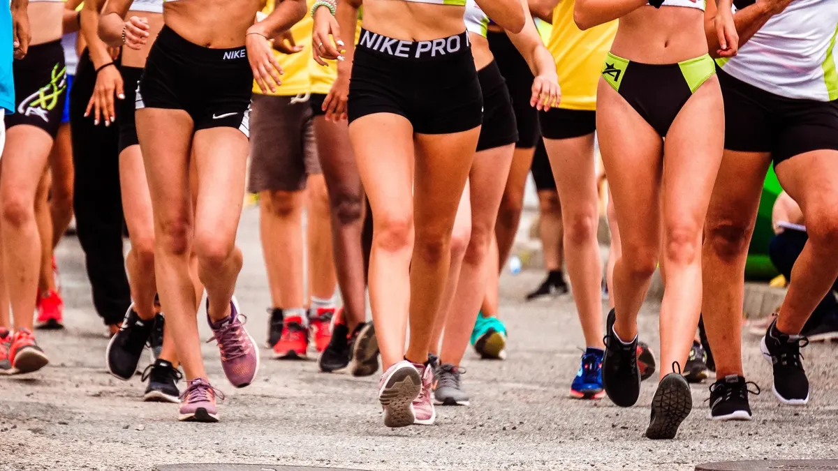 A group of runners participating in an outdoor street marathon wearing athletic gear.