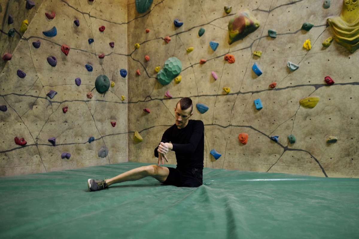 Person Dehnt Arme und Beine in einem Fitnessstudio