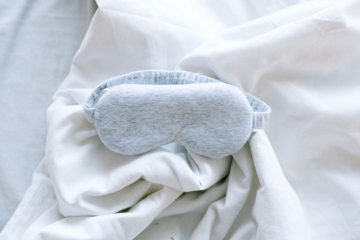 Antifaz para dormir sobre una almohada blanca.
