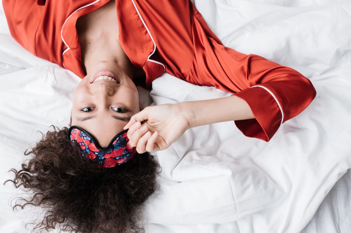 Masque de sommeil en coton sur un lit propre et lumineux.