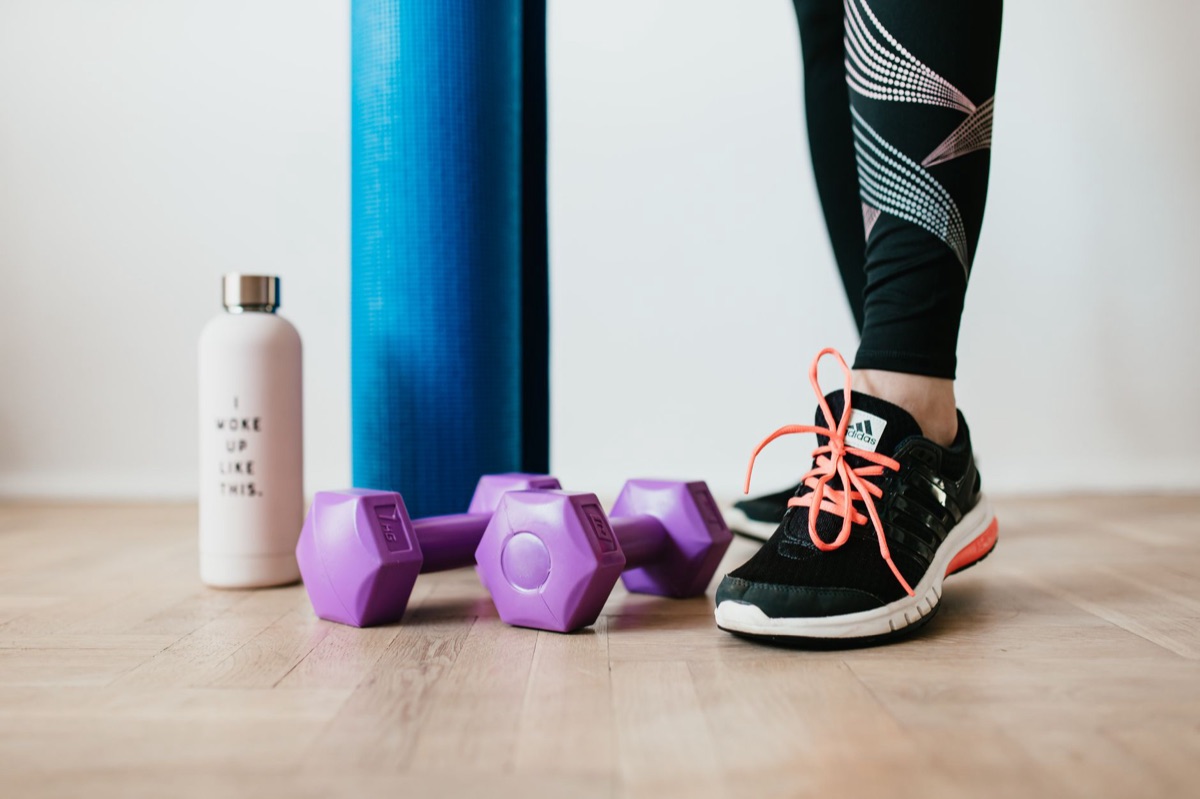 Equipamentos de treino funcional como halteres e tapete de yoga.