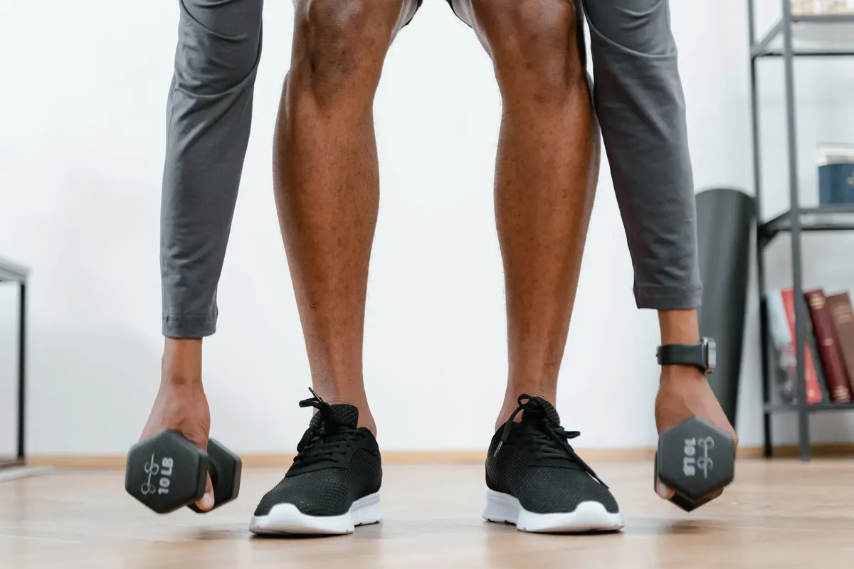 Person engaging in a home workout lifting dumbbells, promoting fitness and healthy living.