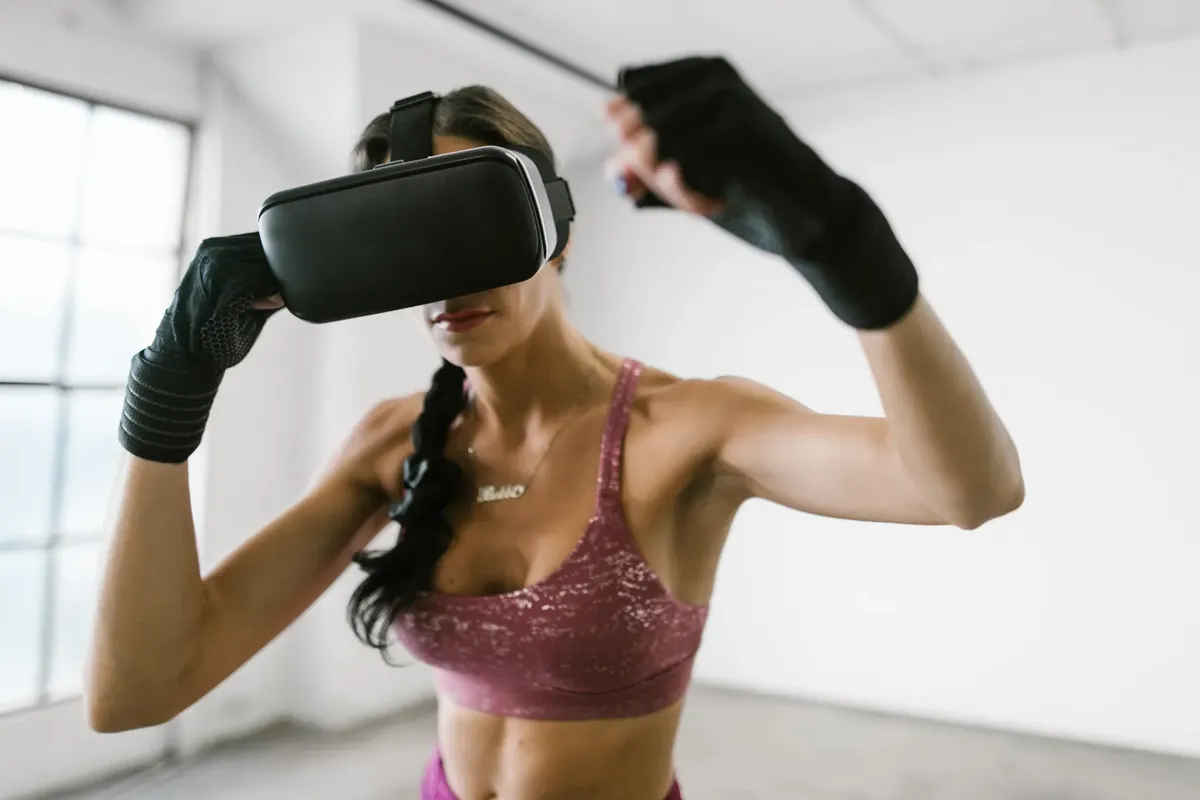 A woman wearing a virtual reality headset, engaged in a fitness workout indoors.
